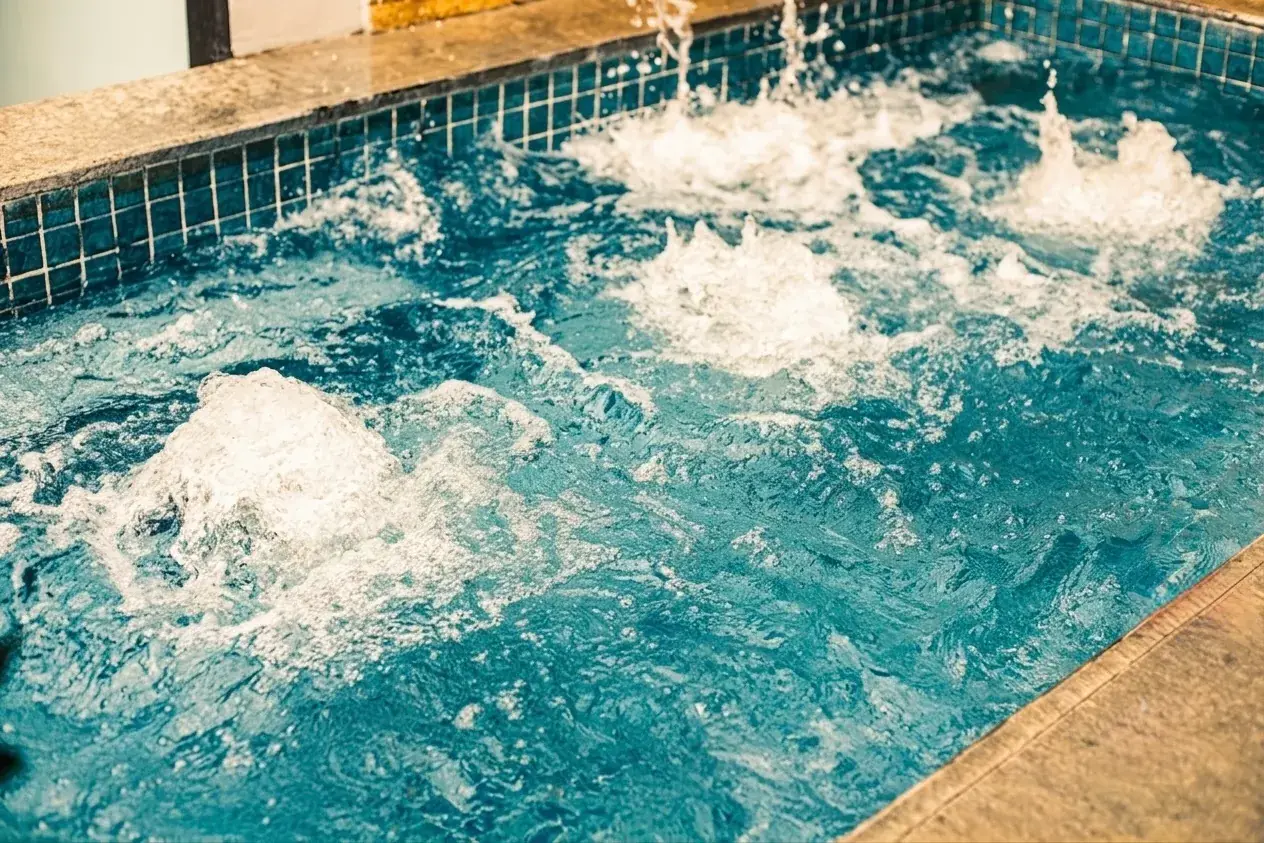 Villa 1 — close-up of the jacuzzi with multiple bubbling jets in a blue-tiled tub