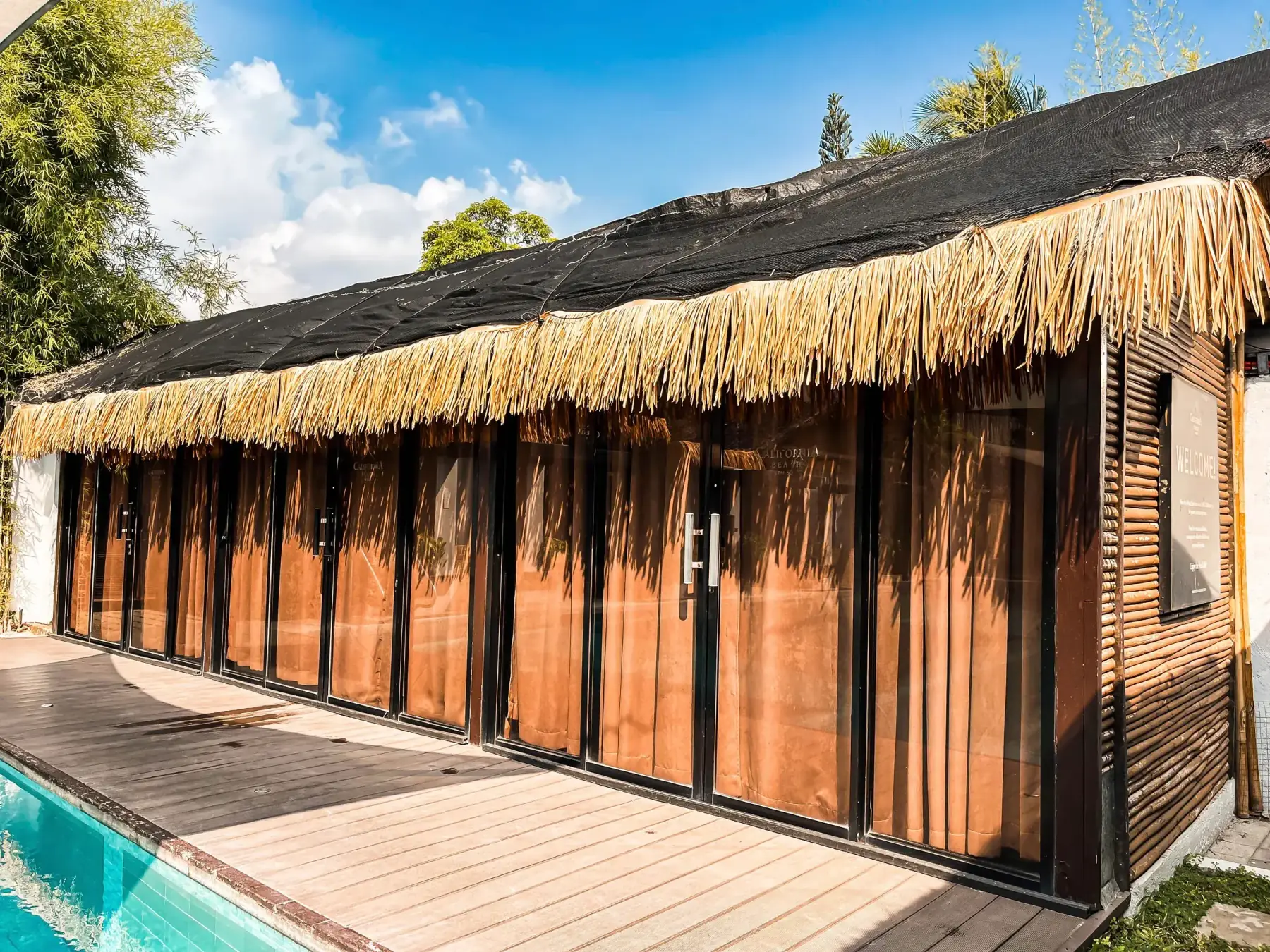 Villa 2 — row of thatch-roofed poolside cabana rooms along the deck