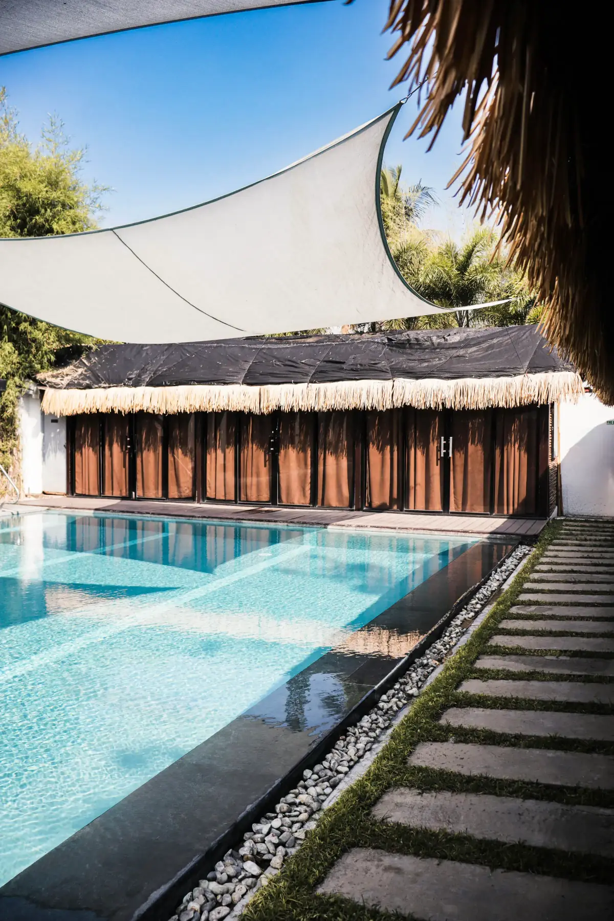 Villa 2 — woven lounge seating on the pool deck facing the clubhouse