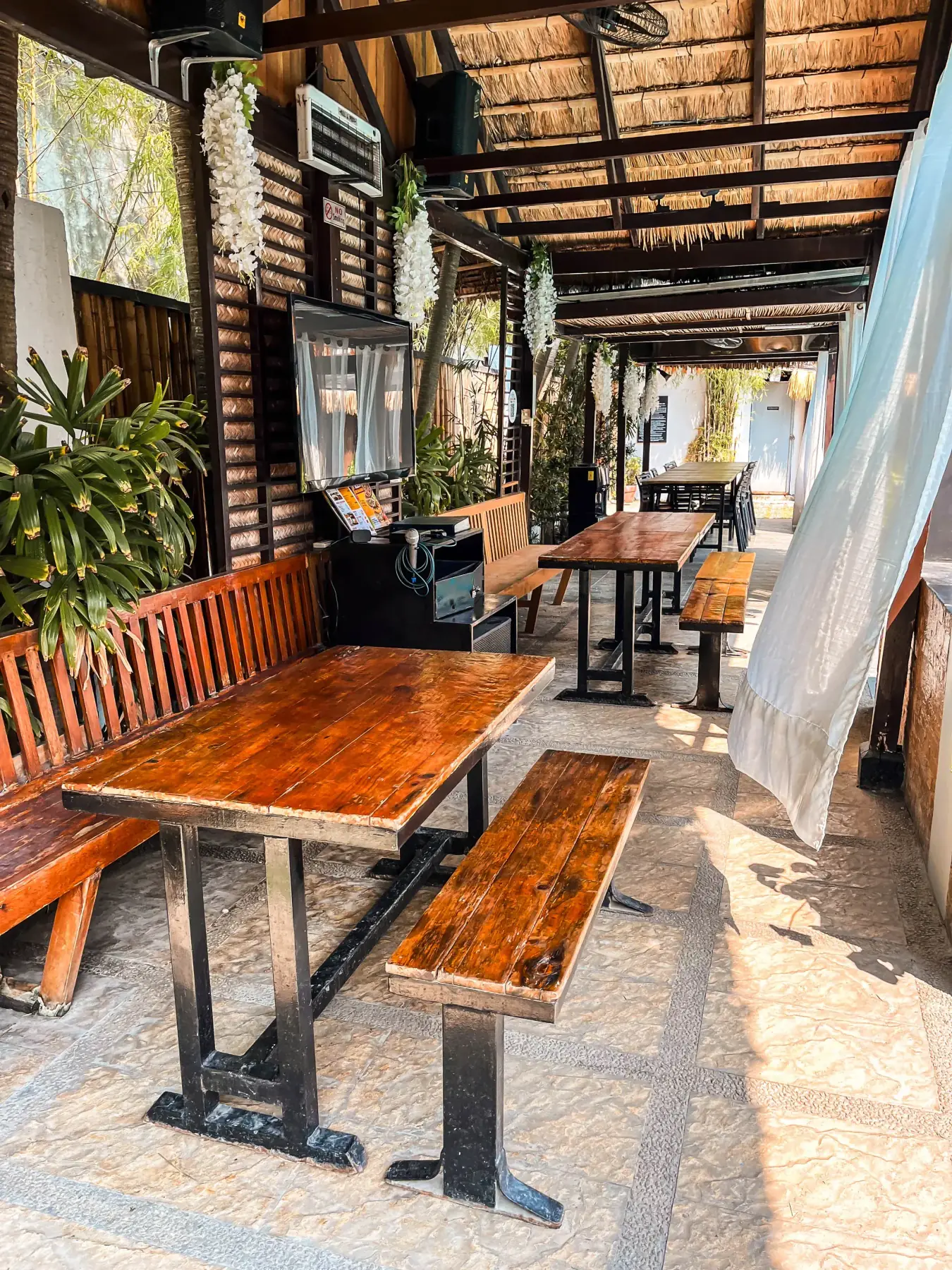 Villa 2 — covered outdoor dining area with wall-mounted videoke TV