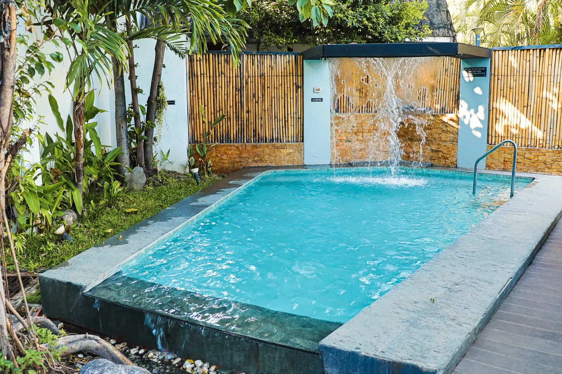 Villa 2 — private plunge pool with waterfall spout behind a bamboo screen