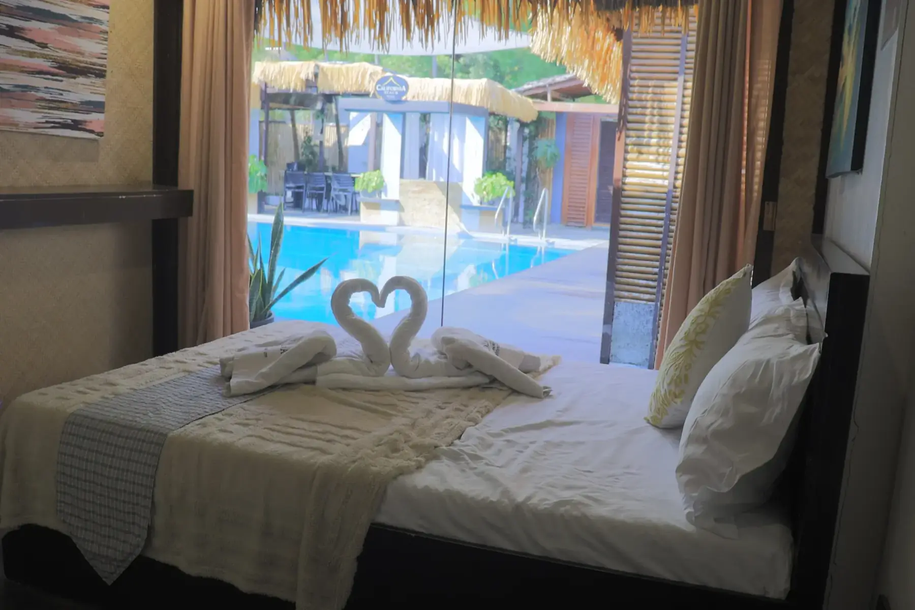 Villa 2 — pool-view bedroom with a feather-print triptych