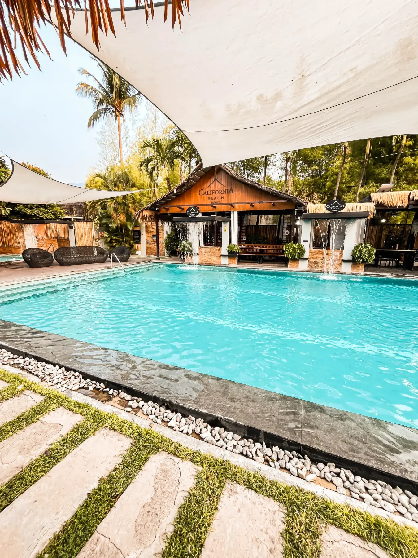 Villa 2 — private pool and clubhouse with poolside rattan seating