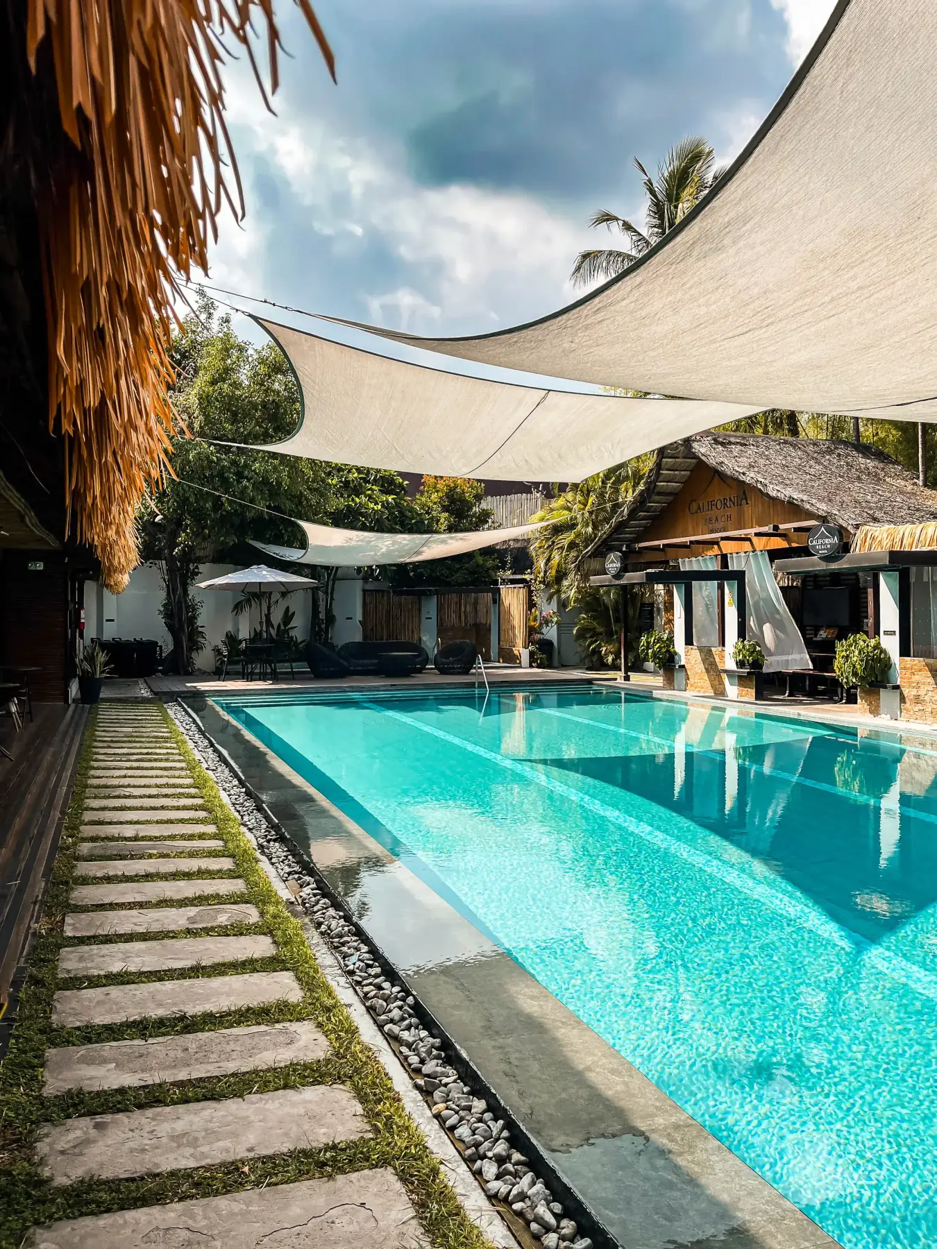 Villa 2 — stepping-stone path along the private pool toward the clubhouse