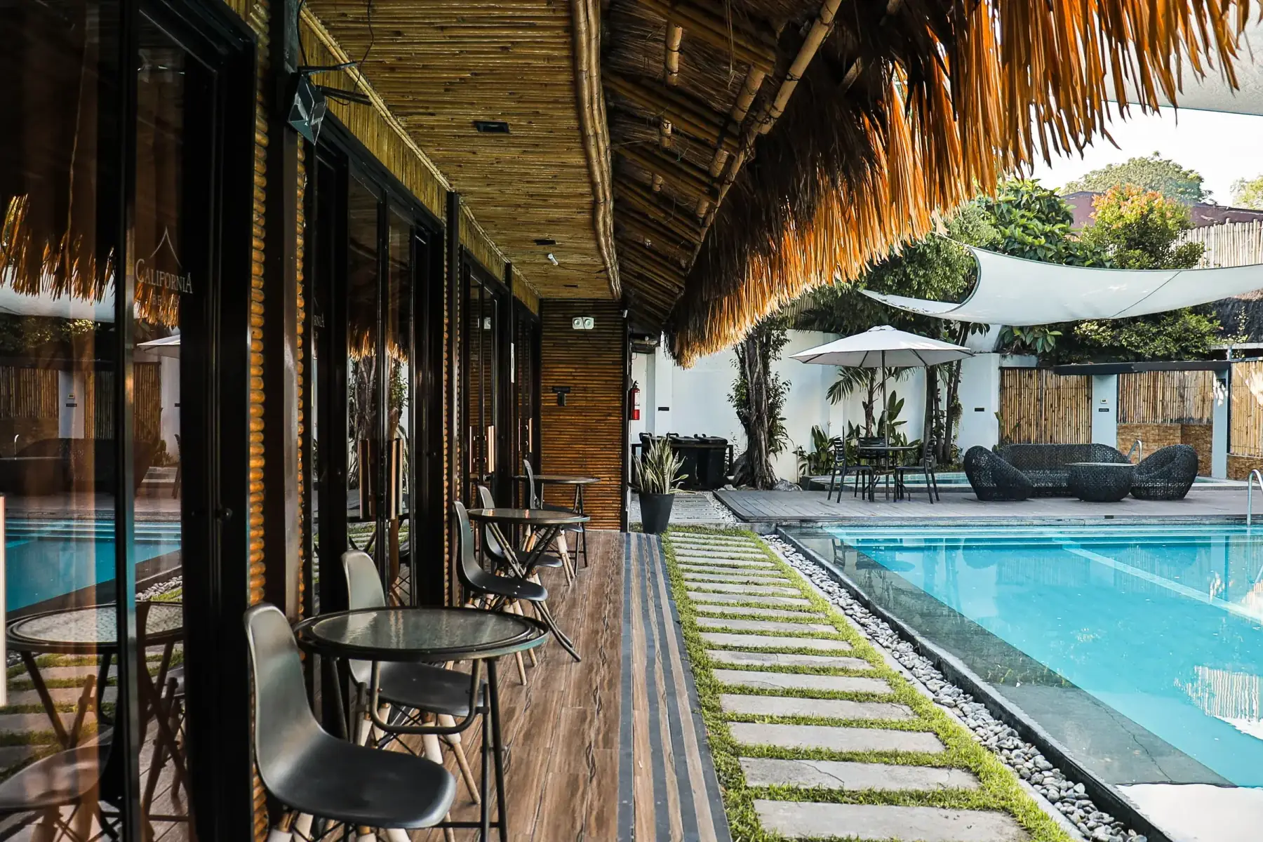 Villa 2 — covered poolside walkway with bistro tables