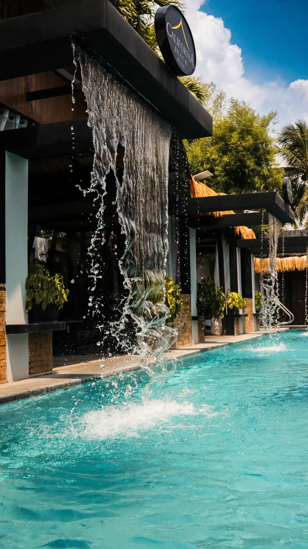 Villa 2 — waterfalls streaming off the cabana ledges into the pool