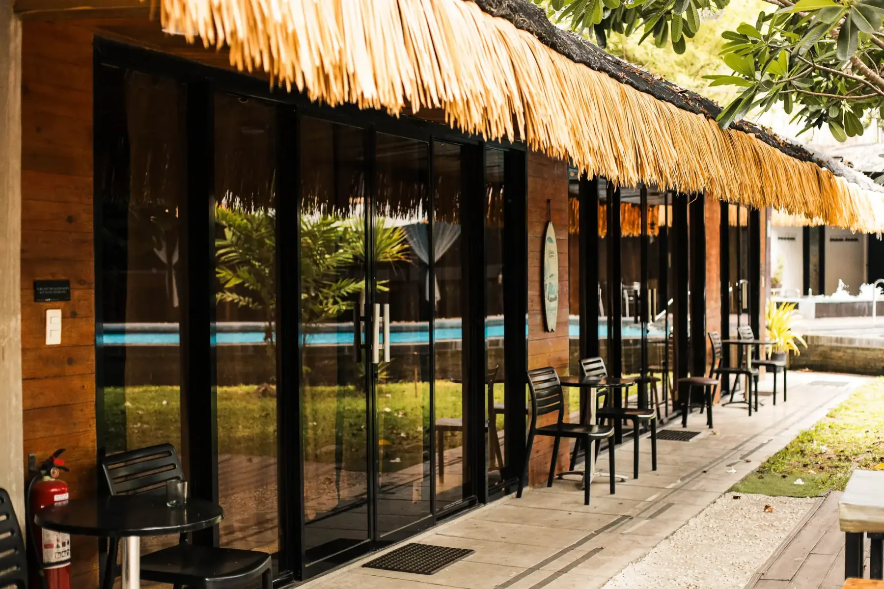 California Beach Pansol Villa 3 — thatch-roof facade reflected in the private pool