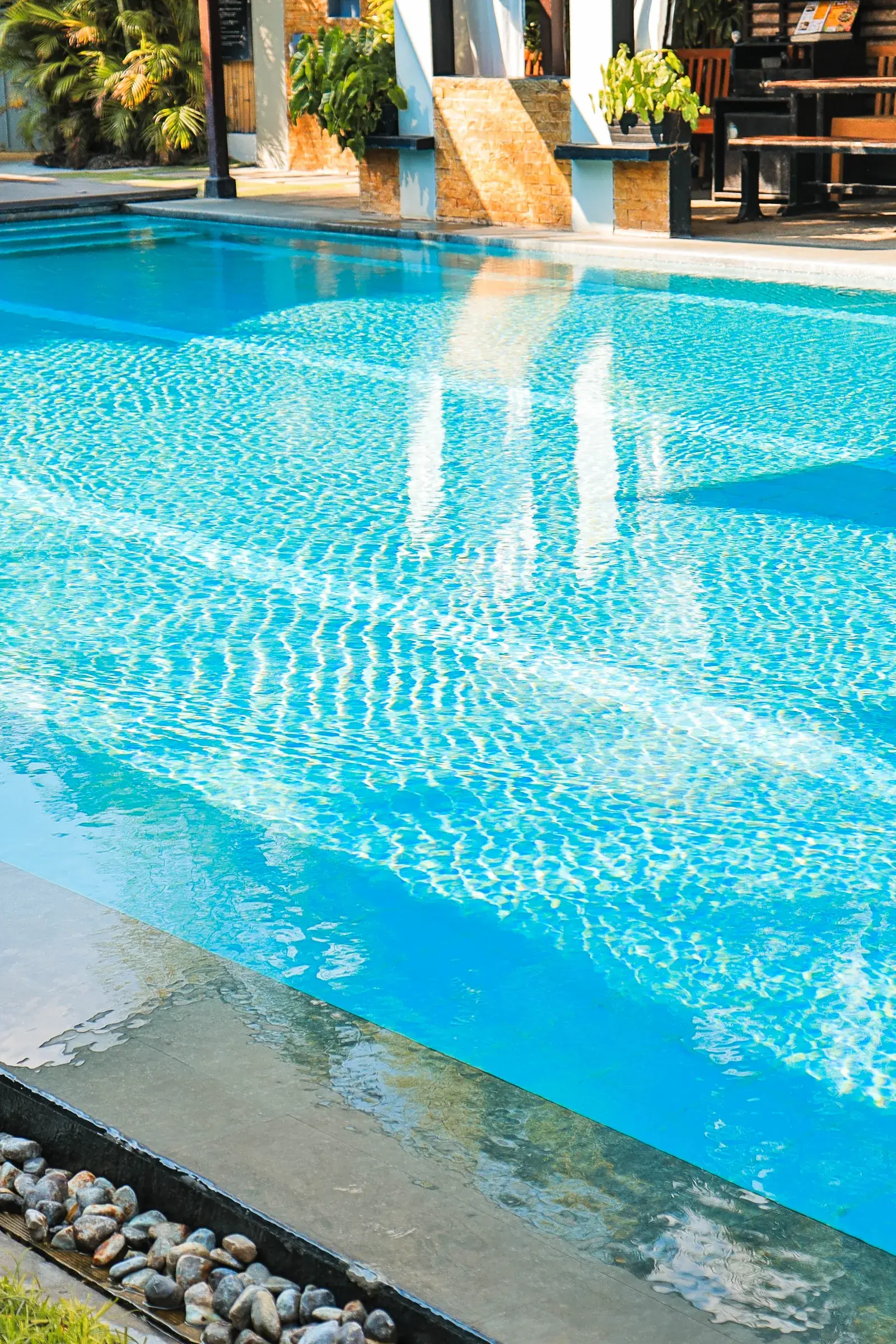 California Beach Pansol — sunlight rippling across the turquoise water of the private pool beside the poolside clubhouse